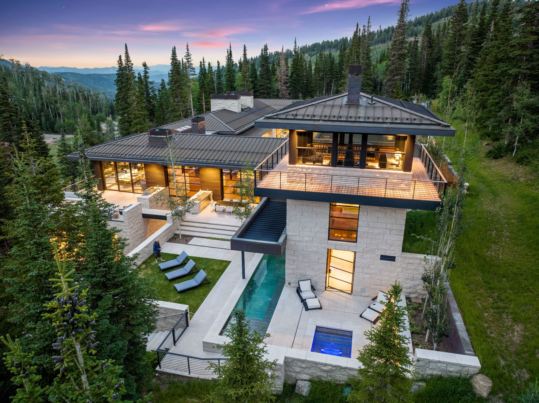 Contemporary residence featuring a multi-level design with a metal roof and extensive glass