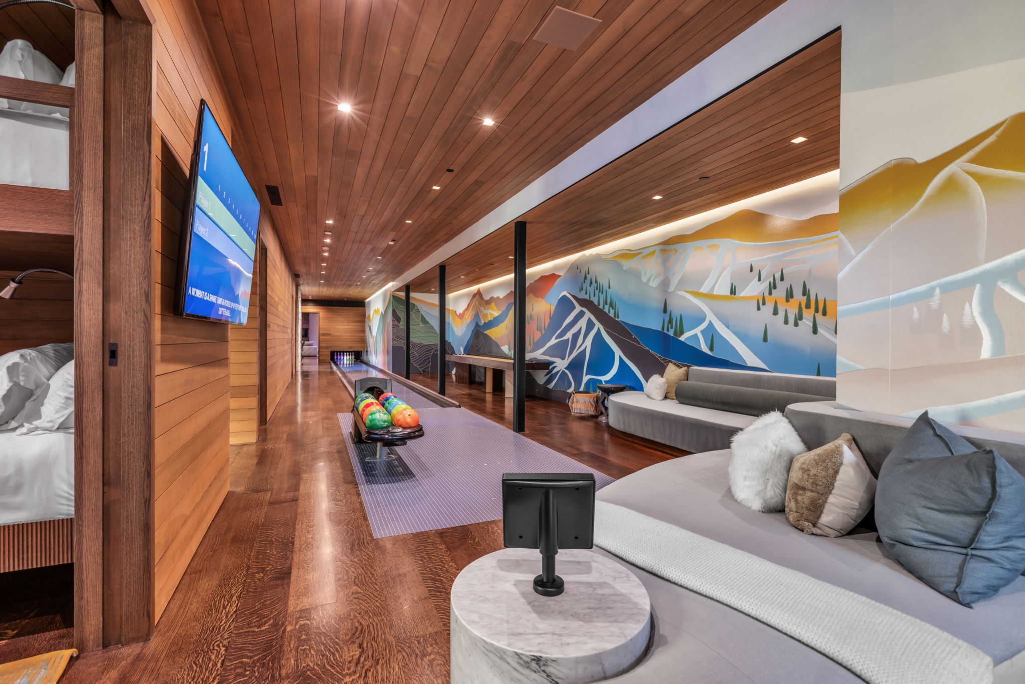 Recreational space featuring a built-in bowling lane, wood-finish flooring, wood plank ceiling, and illuminated wall art