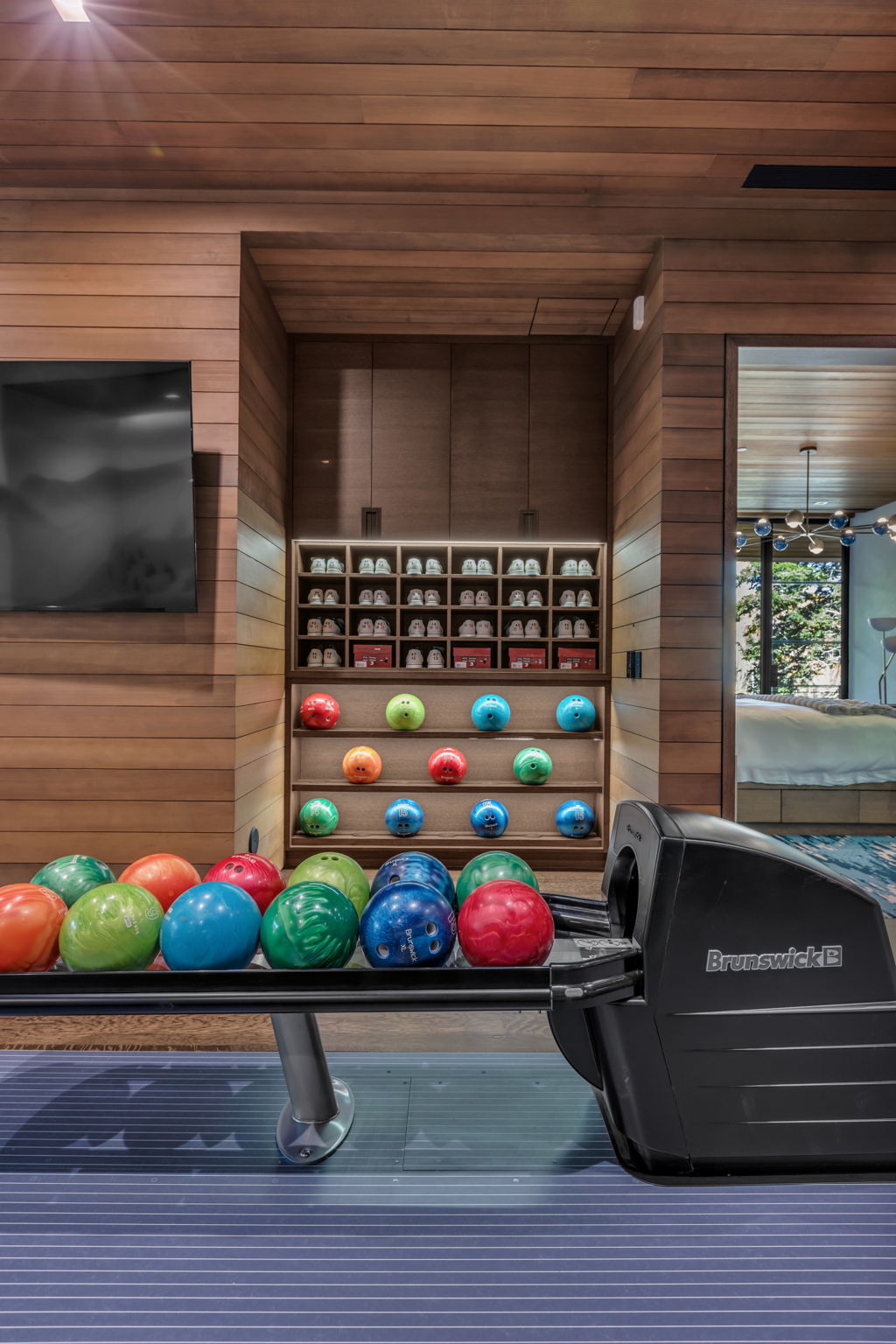Bowling alley featuring a Brunswick ball return system and wood-paneled walls