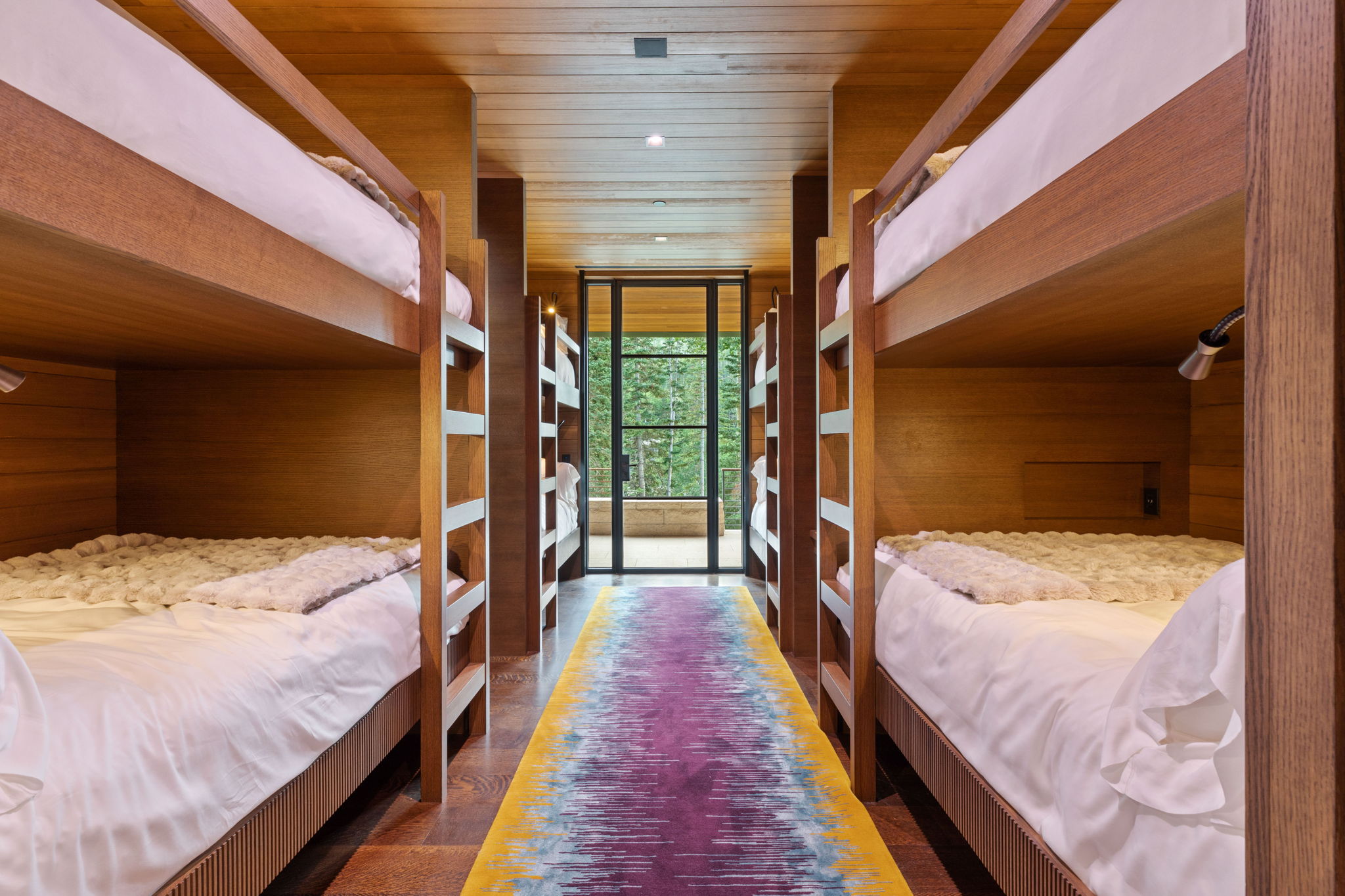 Bunk room featuring built-in wooden bunk beds, recessed lighting, and individual reading lights