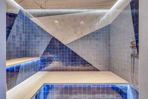 Custom tiled shower enclosure featuring a geometric pattern of blue and white square tiles