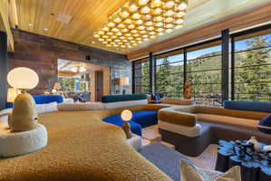 Expansive living area featuring a wood-panel ceiling and an ornate rectangular light fixture