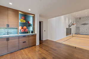 Indoor recreation court with light wood-finish flooring and a basketball hoop