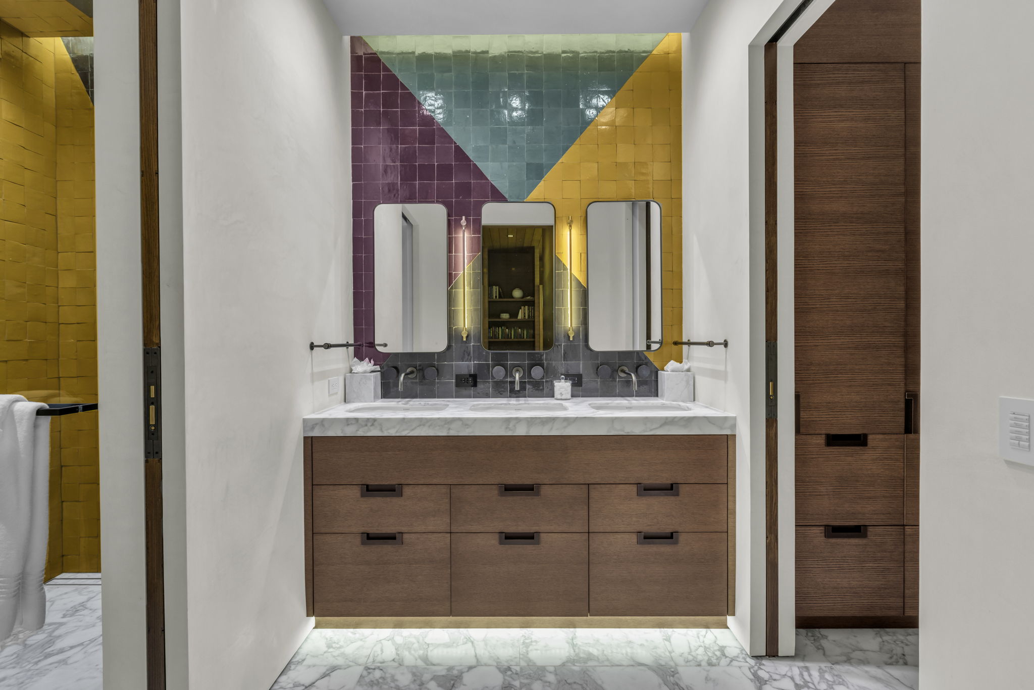 Floating double vanity with a stone countertop, dual undermount sinks, and wall-mounted faucets