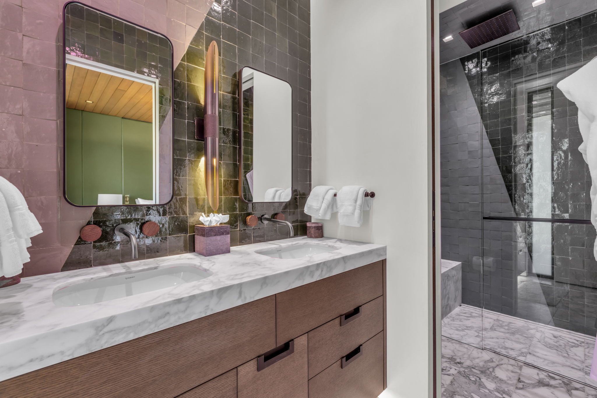 Dual vanity with wood-finish cabinetry, white marble countertop, and undermount sinks