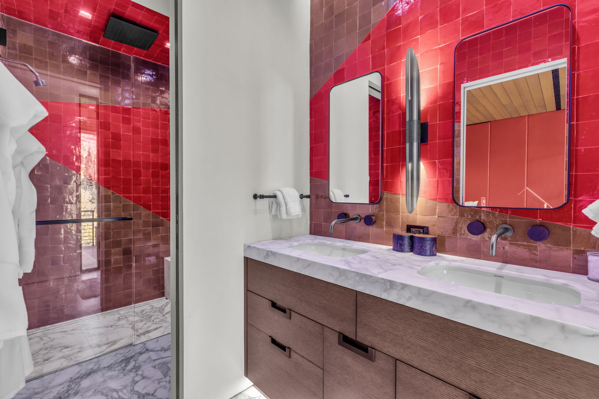 Dual vanity featuring integrated sinks, a marble countertop, and wall-mounted faucets