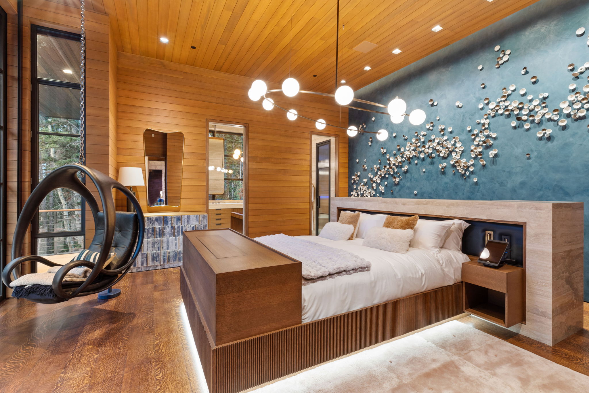 Hardwood flooring and wall paneling complement a ceiling with recessed lighting