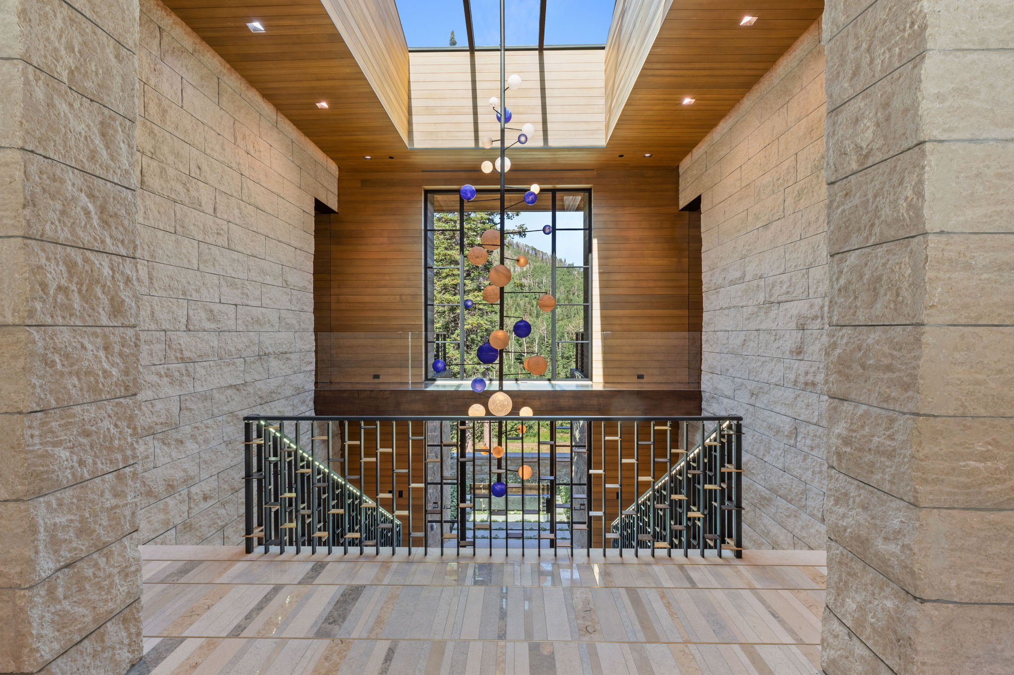Grand hallway with natural stone walls, wood-finish ceiling, and a large skylight