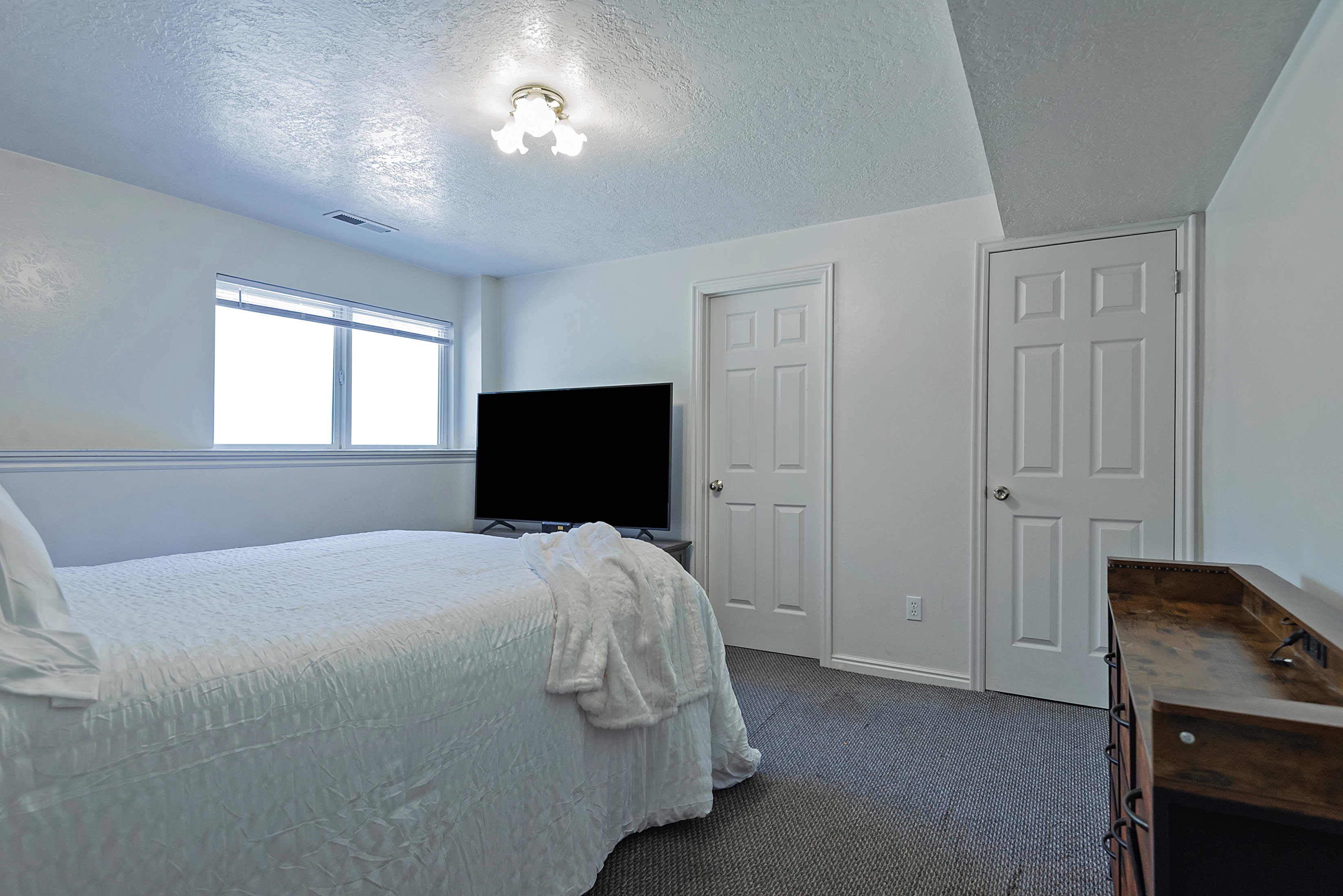 Carpeted room with a double-paned window, white trim, and two paneled doors