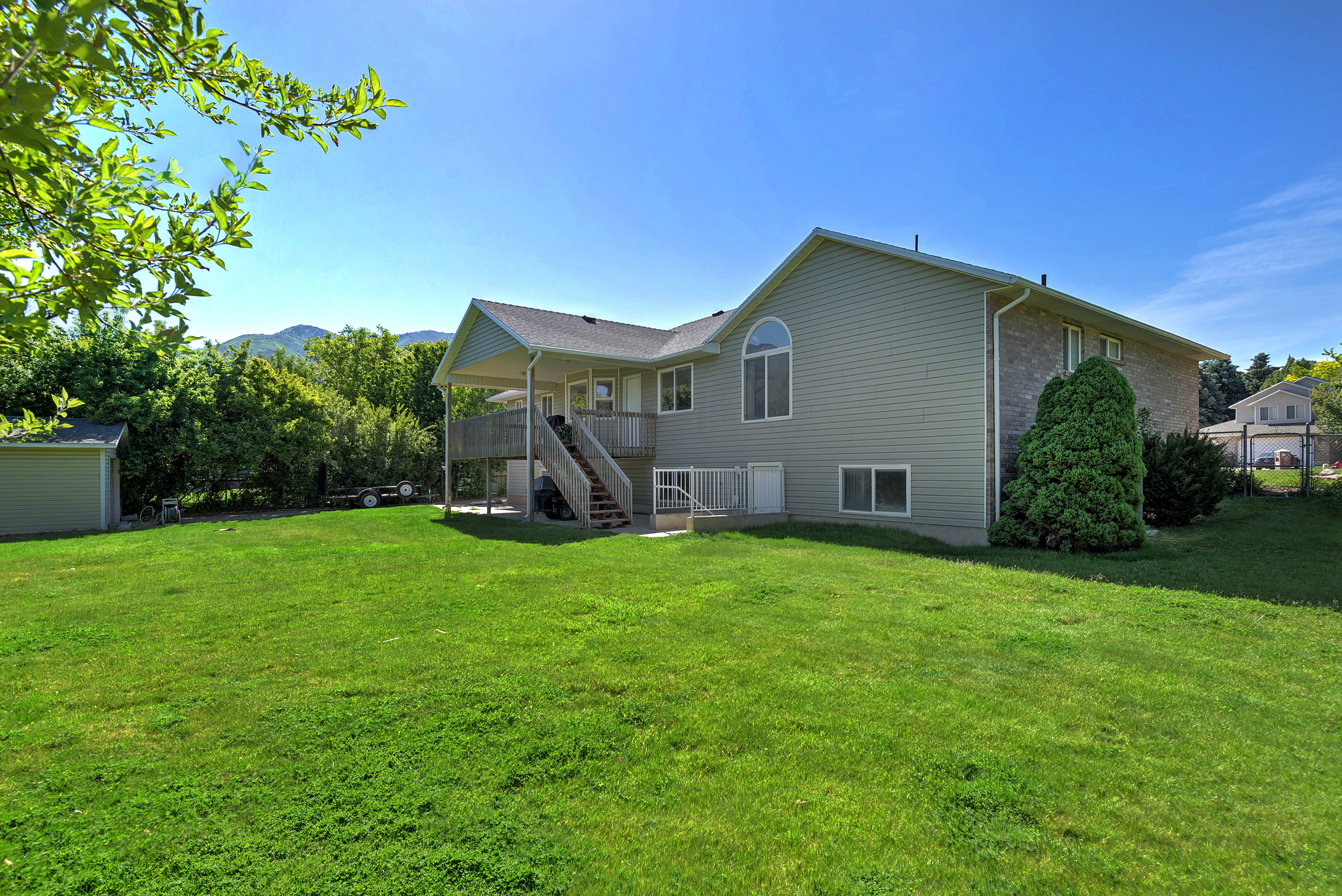 Expansive green lawn with a two-story residence featuring siding and brick accents