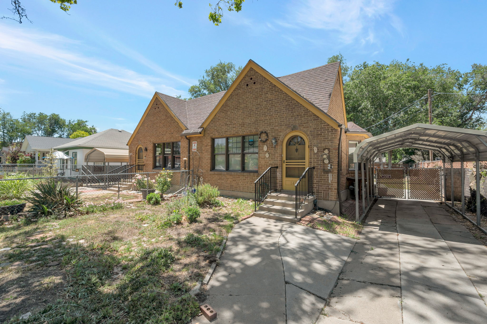 Brick exterior with a gabled roofline, a covered carport, and concrete driveway