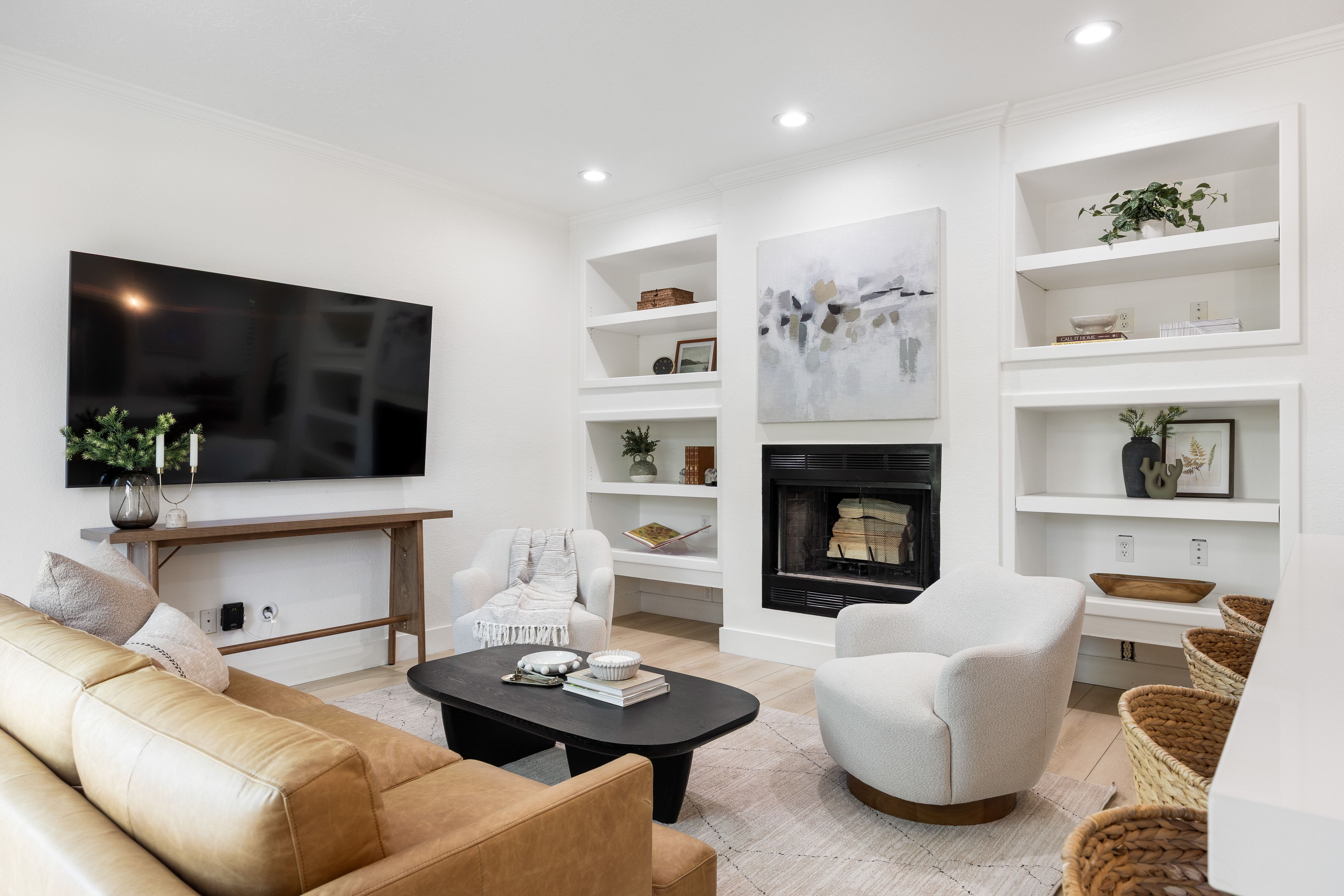 Living area featuring a fireplace with a black surround, integrated shelving, recessed lighting, and wood-finish flooring