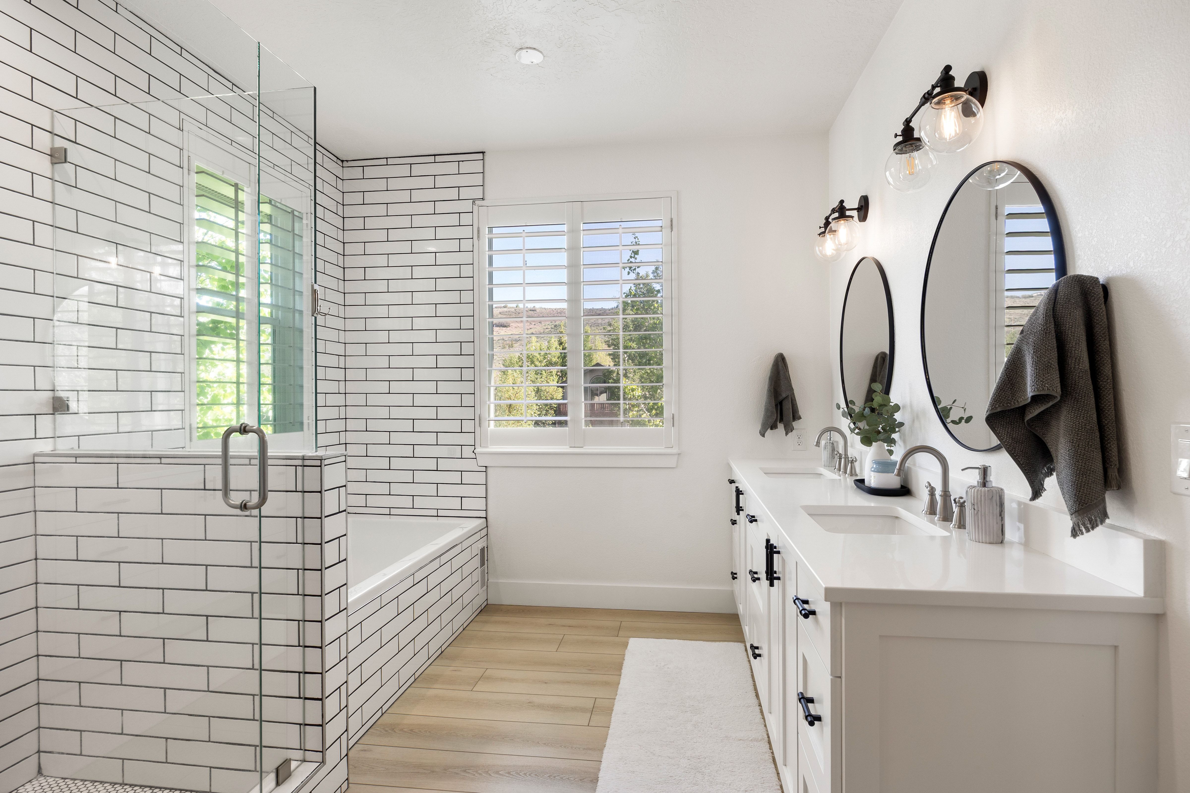 Subway tile shower enclosure with glass paneling and a built-in tub