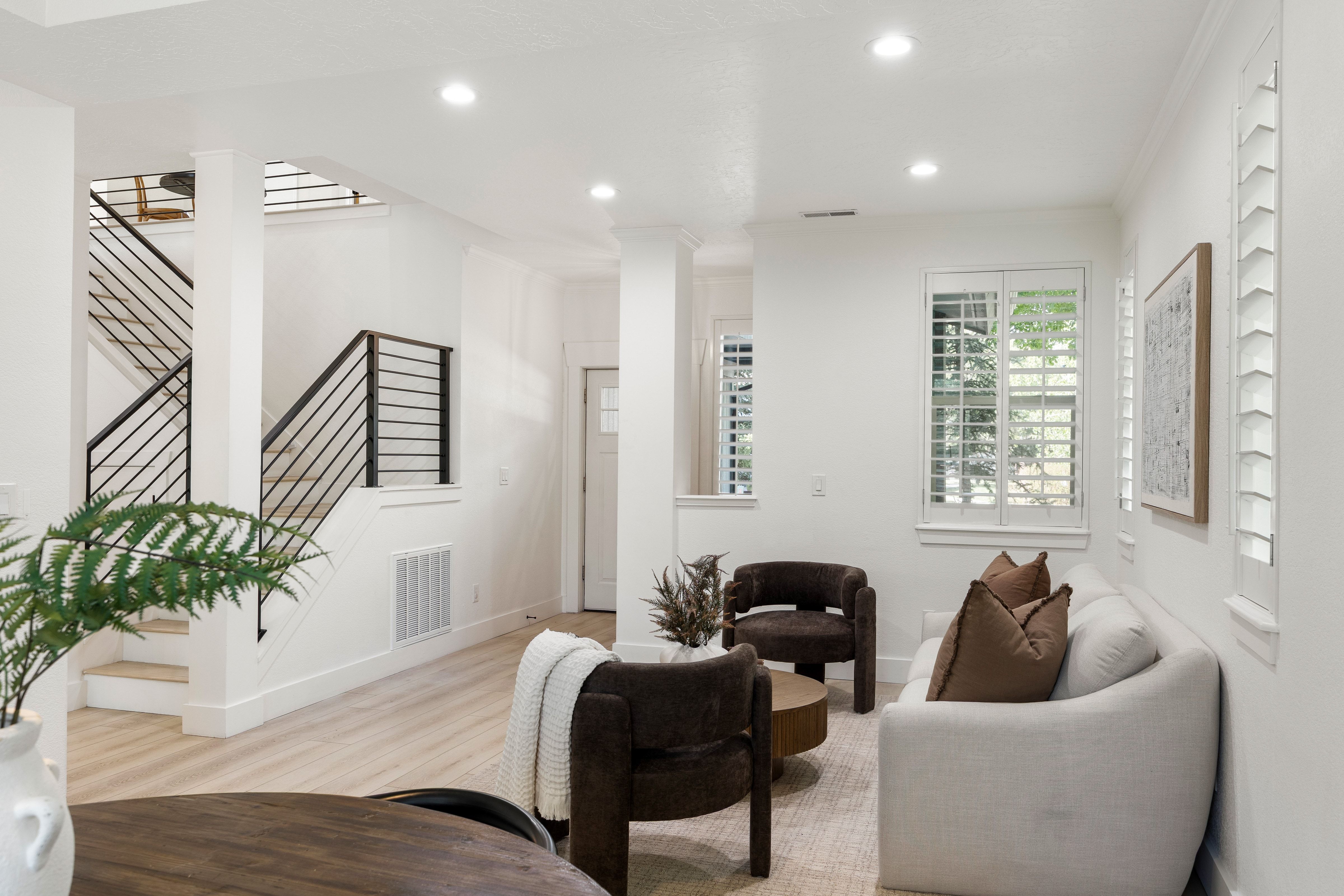 Open-concept living area featuring light wood-finish flooring, recessed lighting, and white plantation shutters