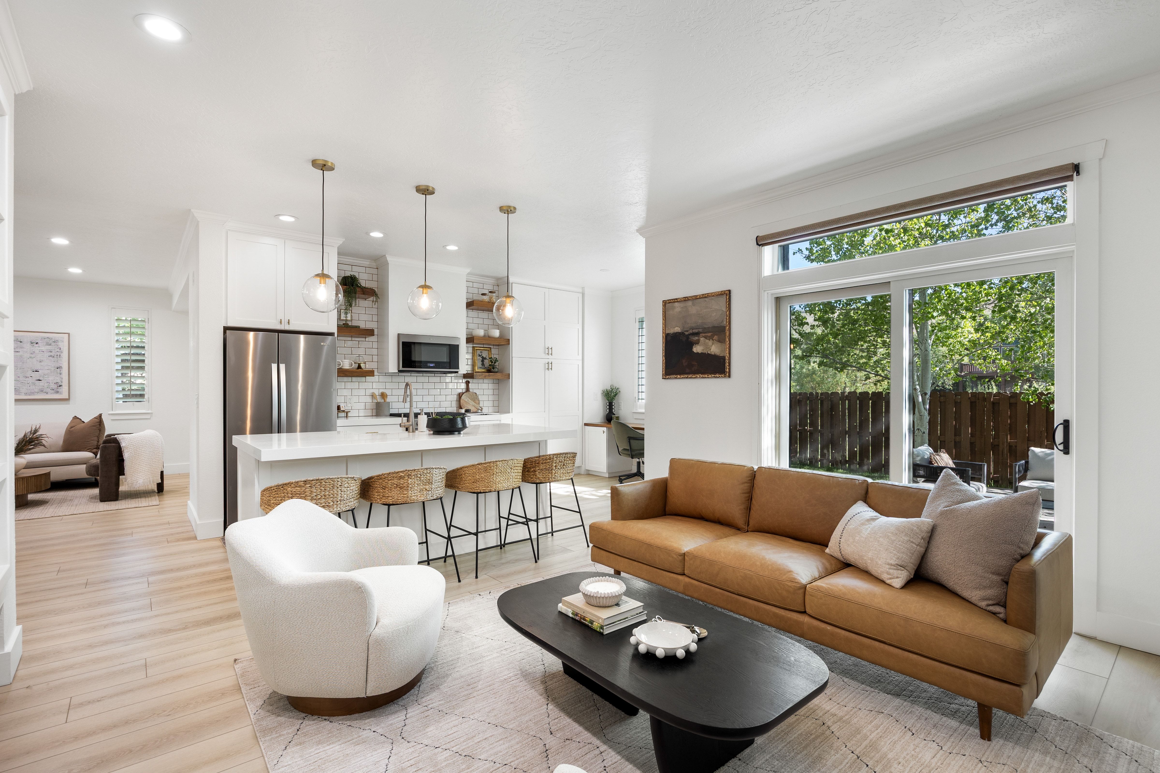 Open-concept living space featuring light wood-finish flooring, white walls, and recessed lighting