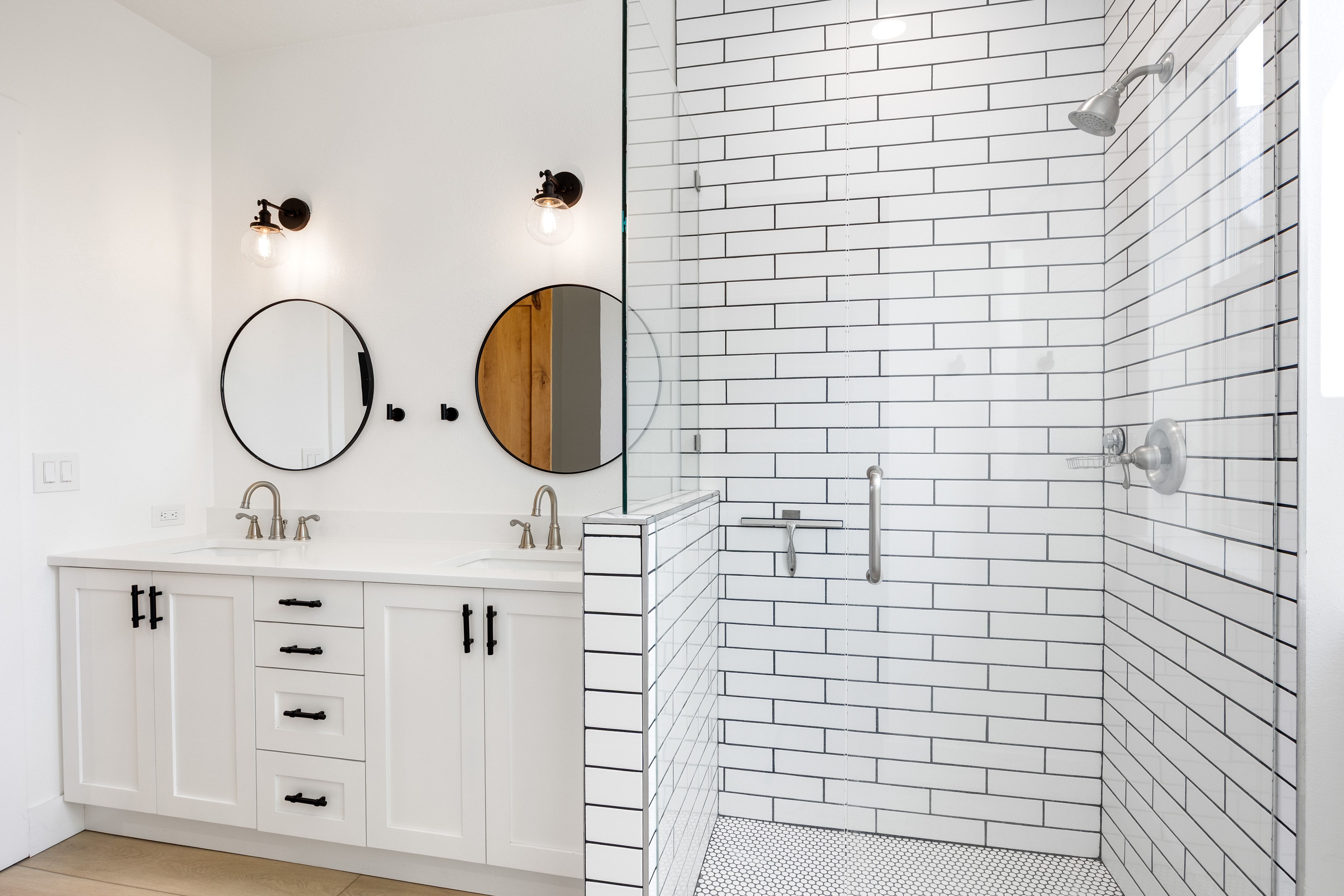 Contemporary bathroom featuring a spacious glass-enclosed shower with white subway tile and a penny tile floor