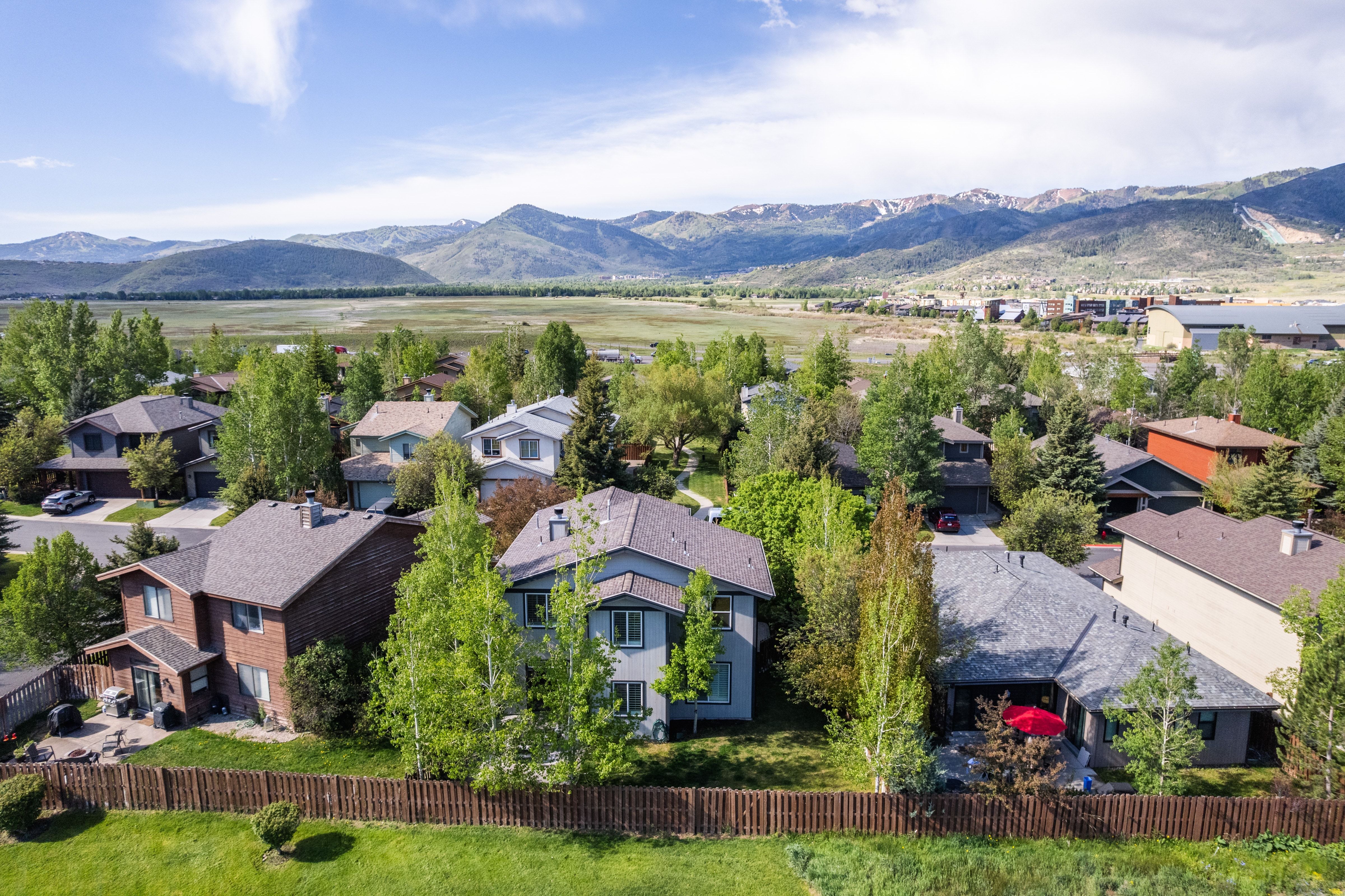 Expansive community with varied architectural styles, mature trees, and mountainous terrain