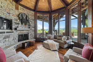 Living area featuring a stone-clad fireplace and a built-in media cabinet