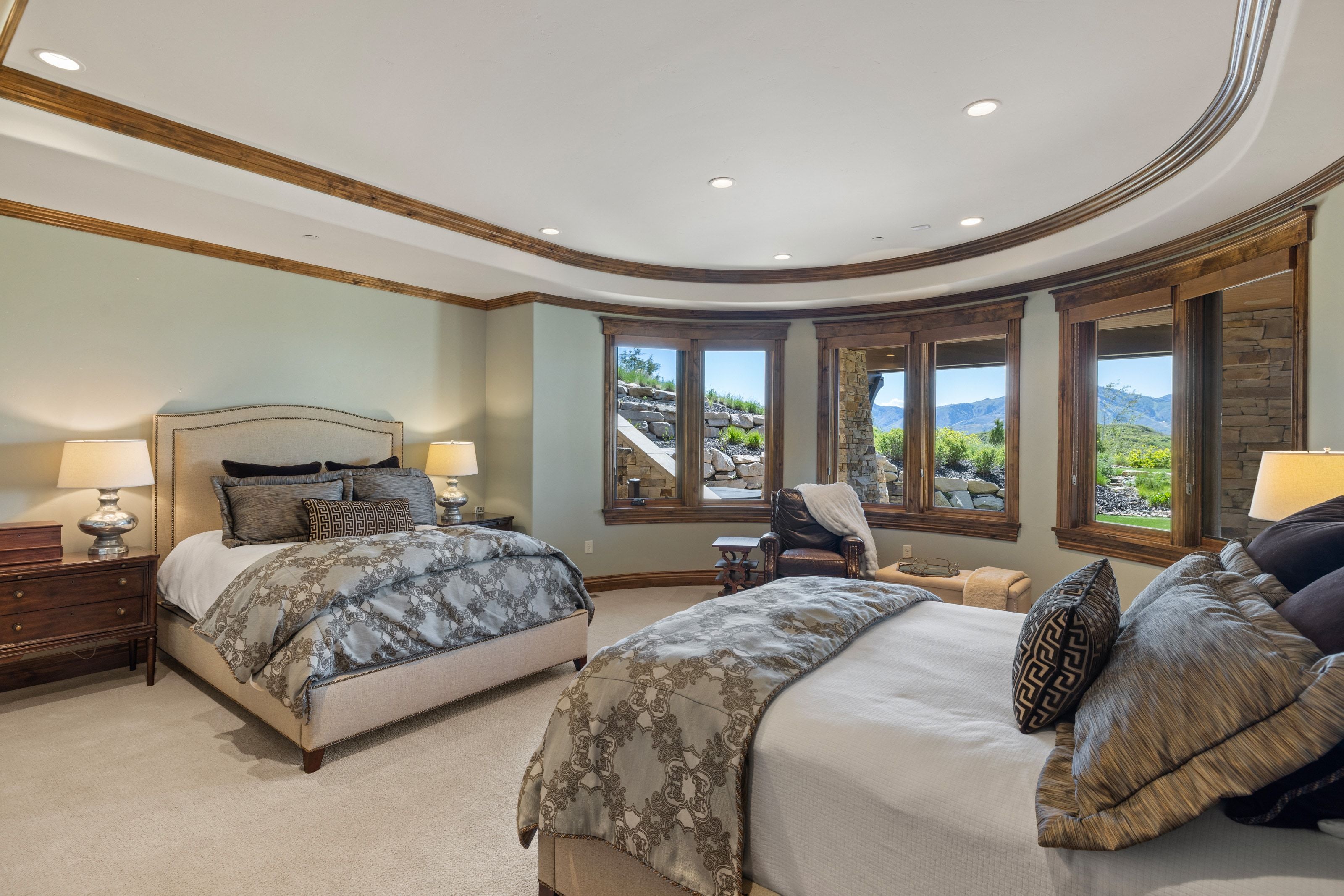 Carpeted interior with a curved wall of multiple windows featuring wood-frame trim
