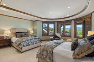 Carpeted interior with a curved wall of multiple windows featuring wood-frame trim