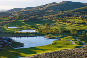 Expansive golf course setting featuring manicured greens, multiple water features, sand traps, and golf cart paths