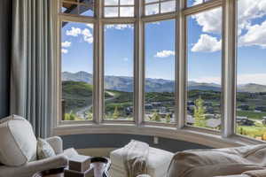Curved bay window framing expansive mountain and distant neighborhood scenery