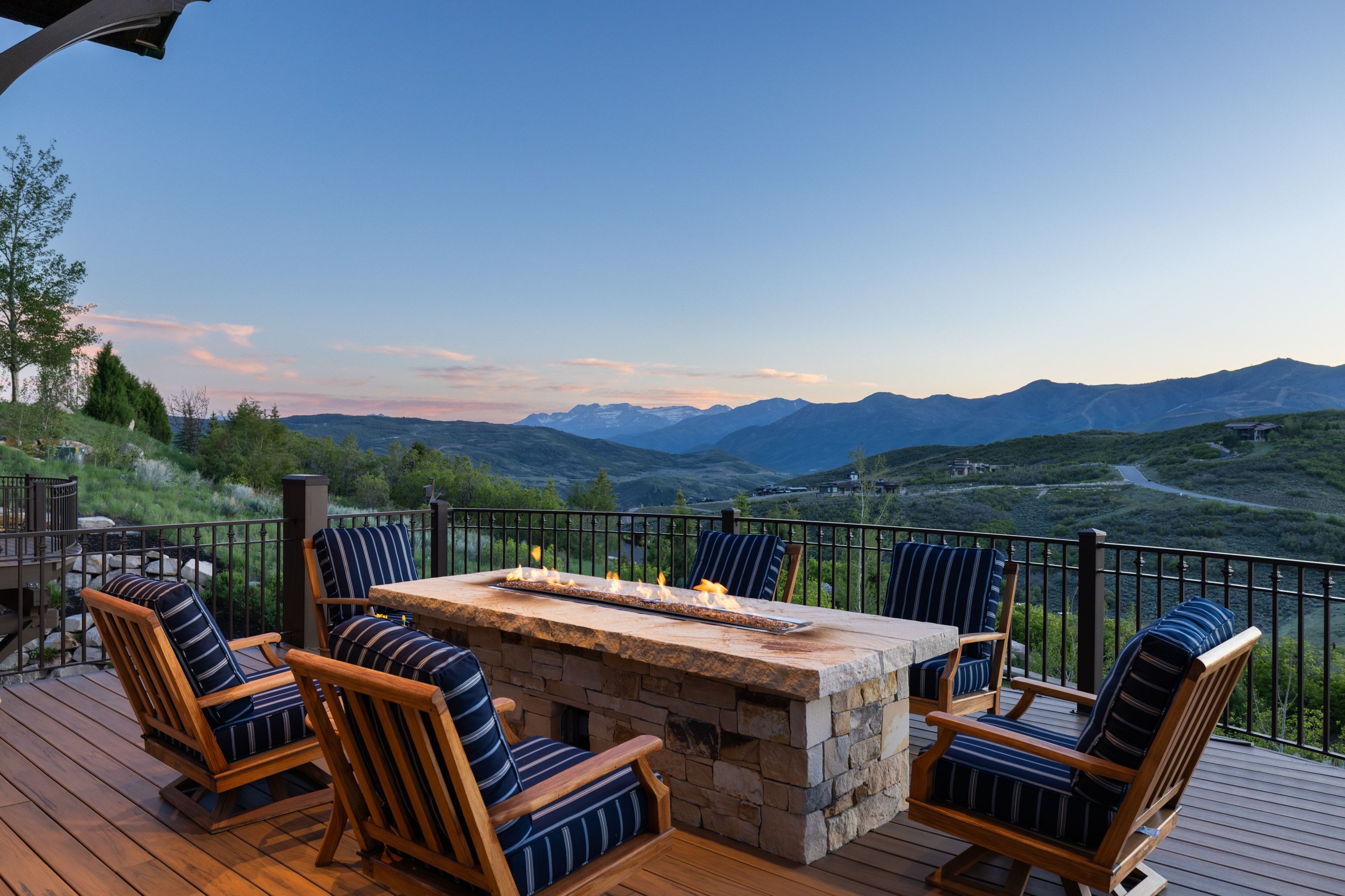Expansive outdoor deck featuring a stone fire pit and dark wood-finish decking