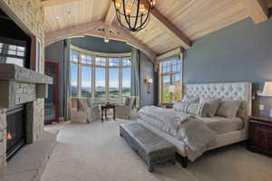 Spacious room featuring vaulted wood-paneled ceilings with exposed beams, a stone fireplace, and a curved bay window with multiple panes
