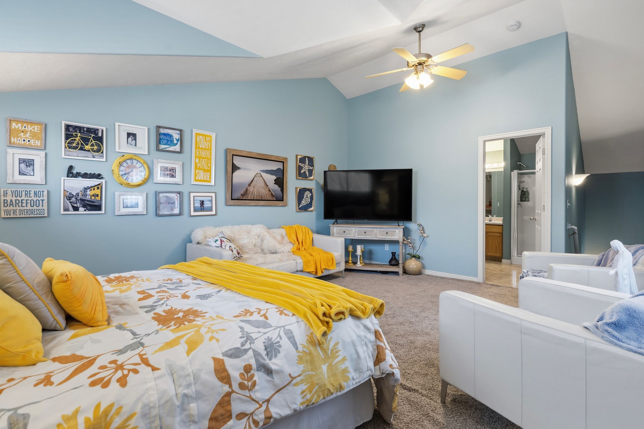 Spacious room featuring vaulted ceilings, a ceiling fan, and light blue wall tones