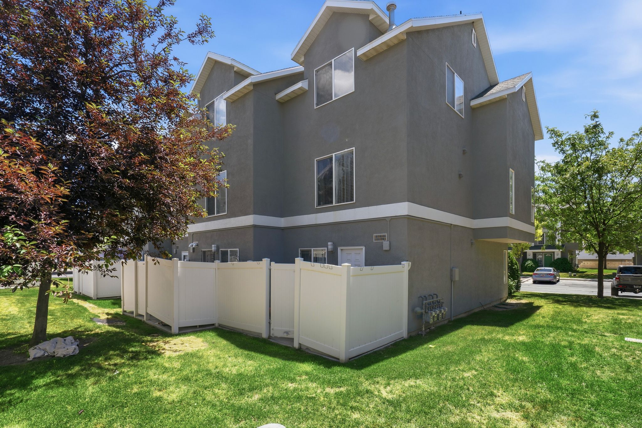 Multi-level exterior with gray stucco siding and white trim
