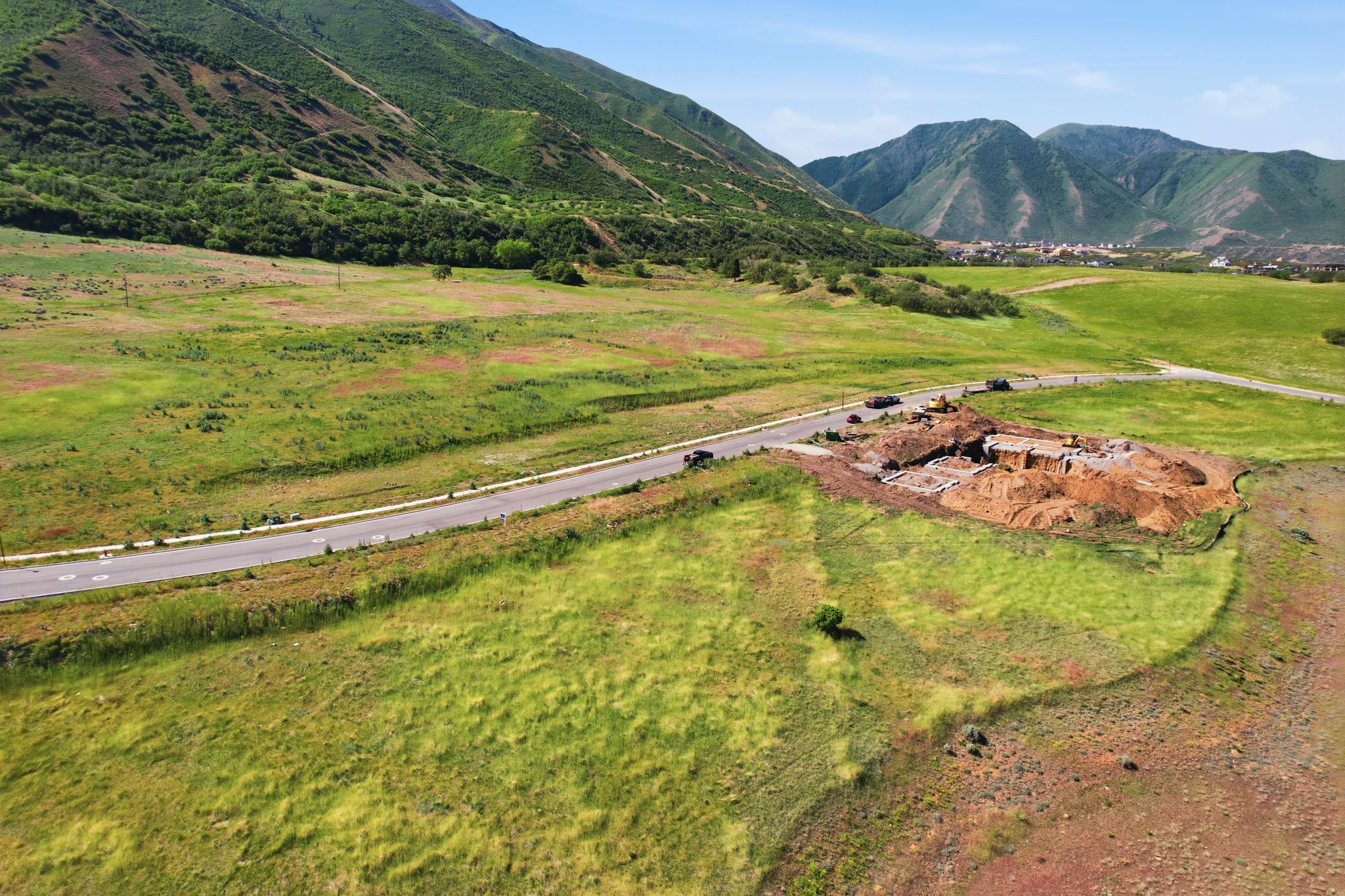 Expansive buildable lot featuring a paved road frontage, utility access, and significant excavation for a new foundation