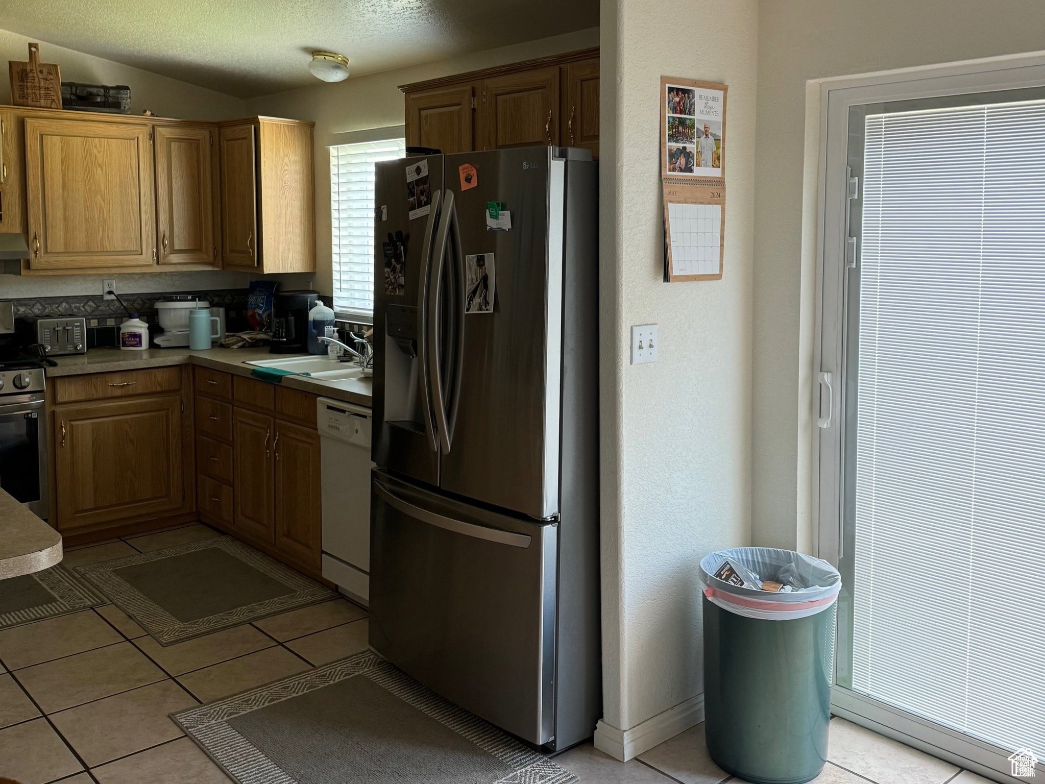 Kitchen featuring wood cabinetry, stone-finish countertops, and tile flooring