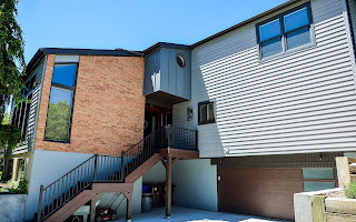 Multi-level facade featuring brick and horizontal siding