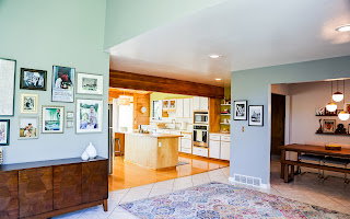 Open-concept living space featuring vaulted ceilings, recessed lighting, tile flooring, and wood-finish flooring