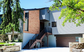 Multi-level contemporary exterior featuring a brick accent facade and horizontal siding