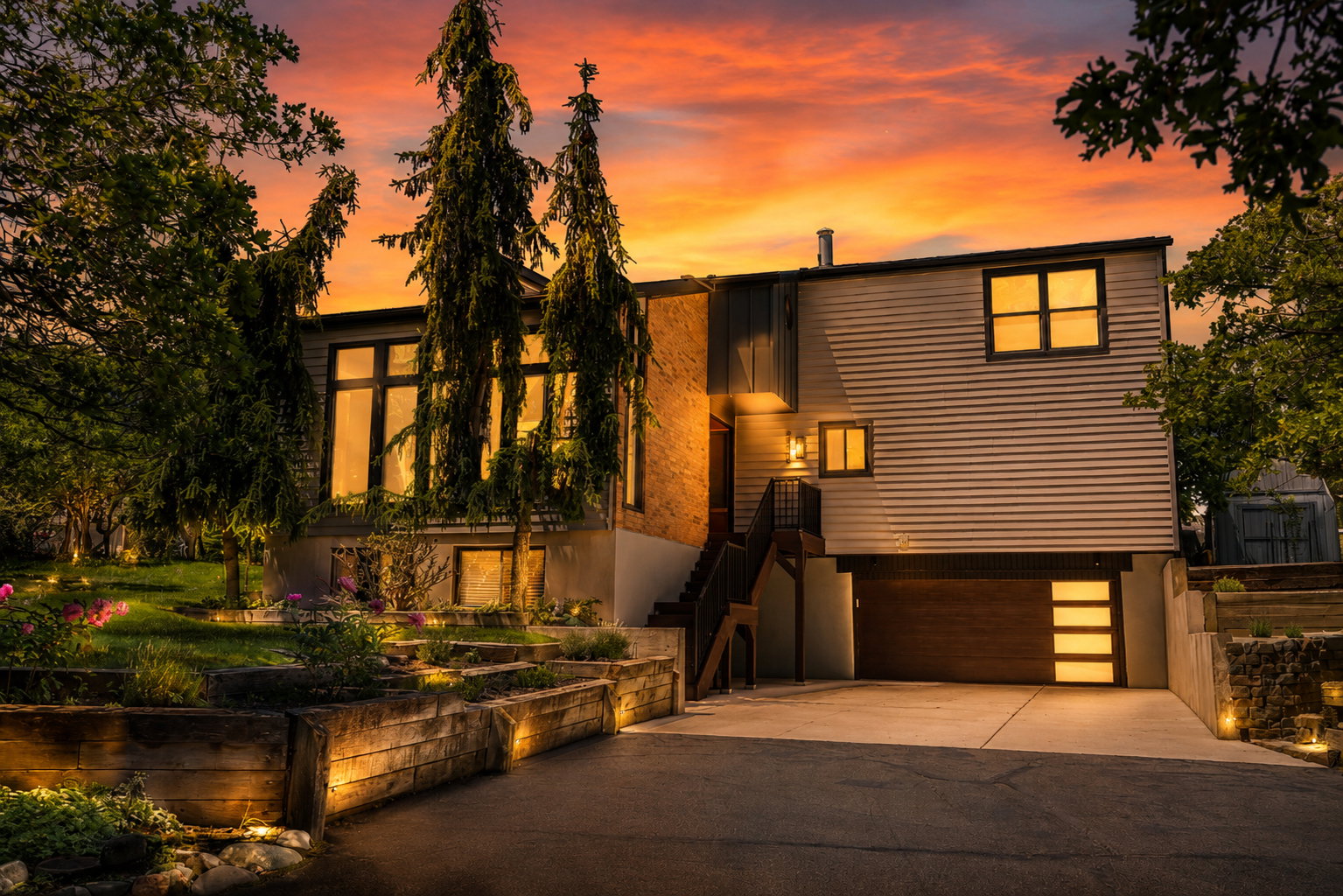 Contemporary residence featuring a multi-level design with expansive windows, horizontal siding, and an integrated garage