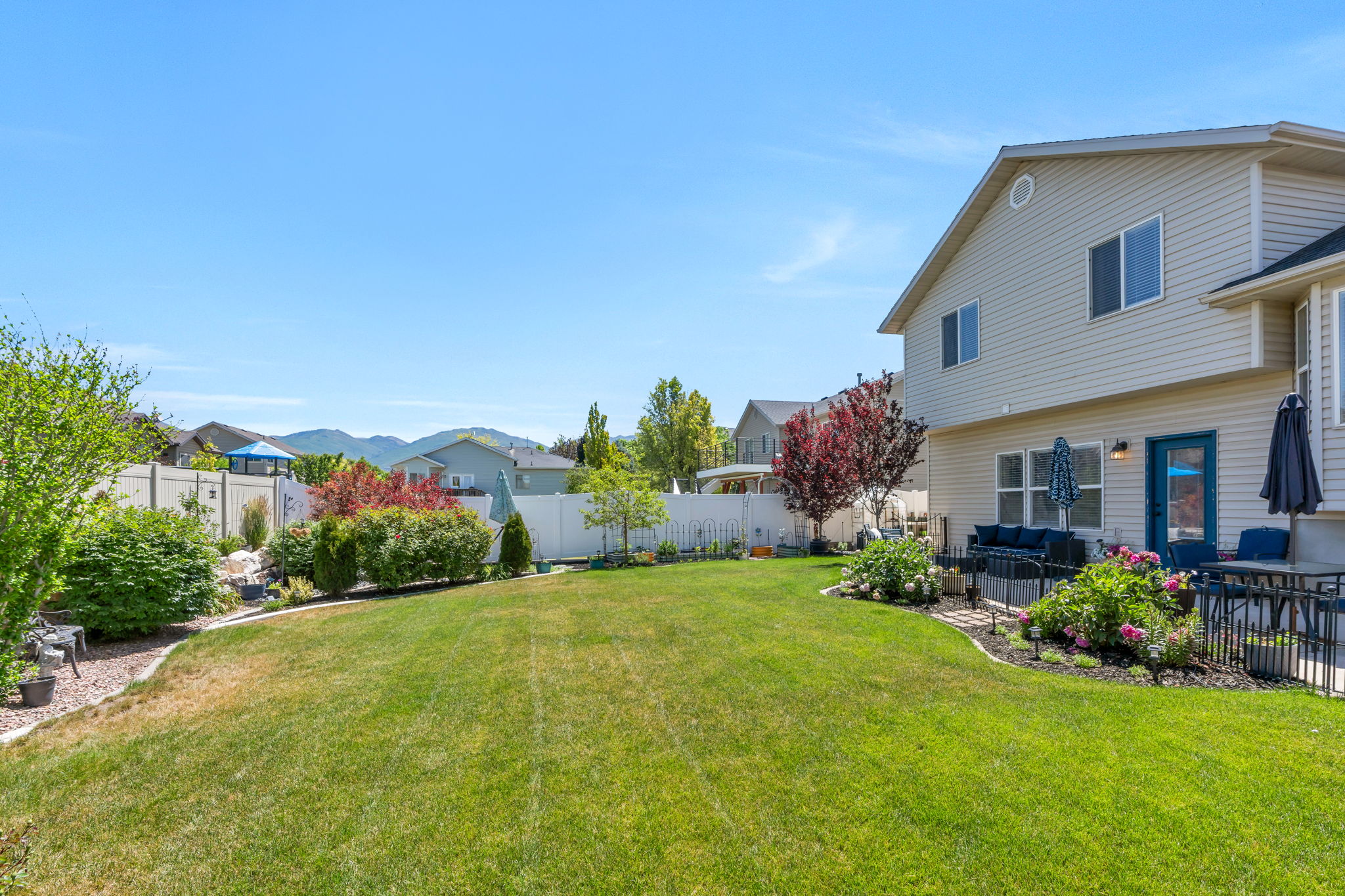 Expansive backyard featuring a manicured lawn and mature landscaping