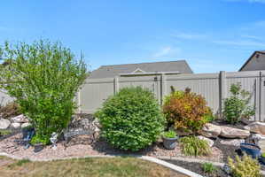 Landscaped garden bed featuring diverse shrubs, rock accents, and dark ground cover