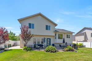Expansive backyard featuring a manicured lawn, a paved patio area, and mature landscaping