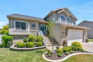 Stucco exterior with brick accenting, a two-car garage, and a front entry with a blue door