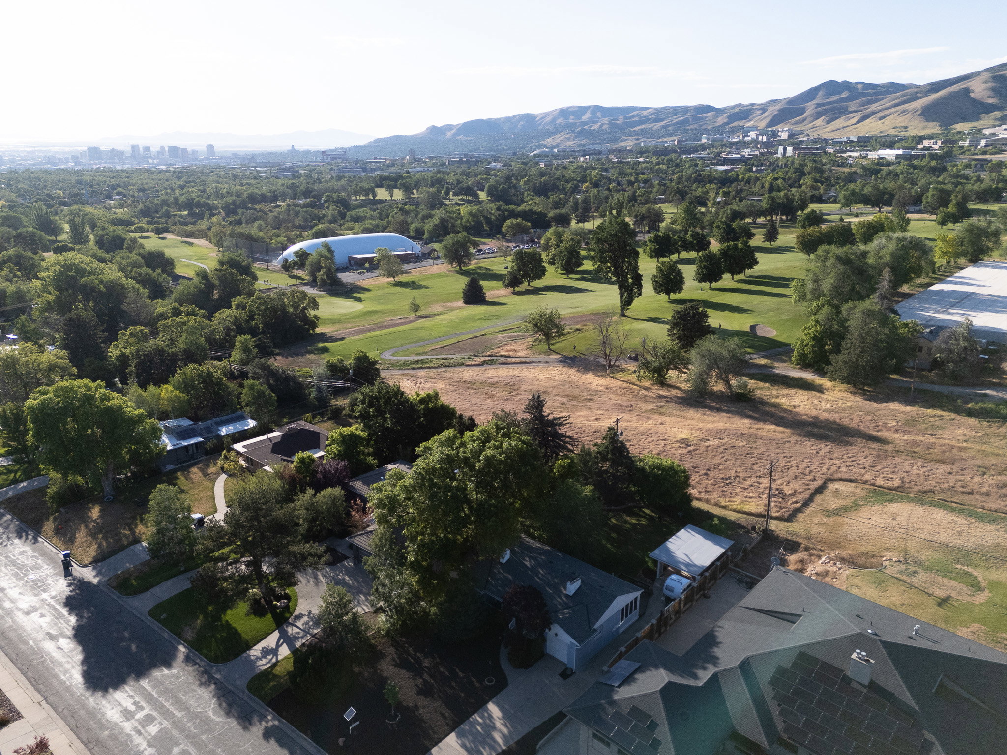 Exceptional location highlighted in Aerial perspective showcasing the property's back yard bordering Bonneville golf course with a stunnning city skyline and mountain backdrop