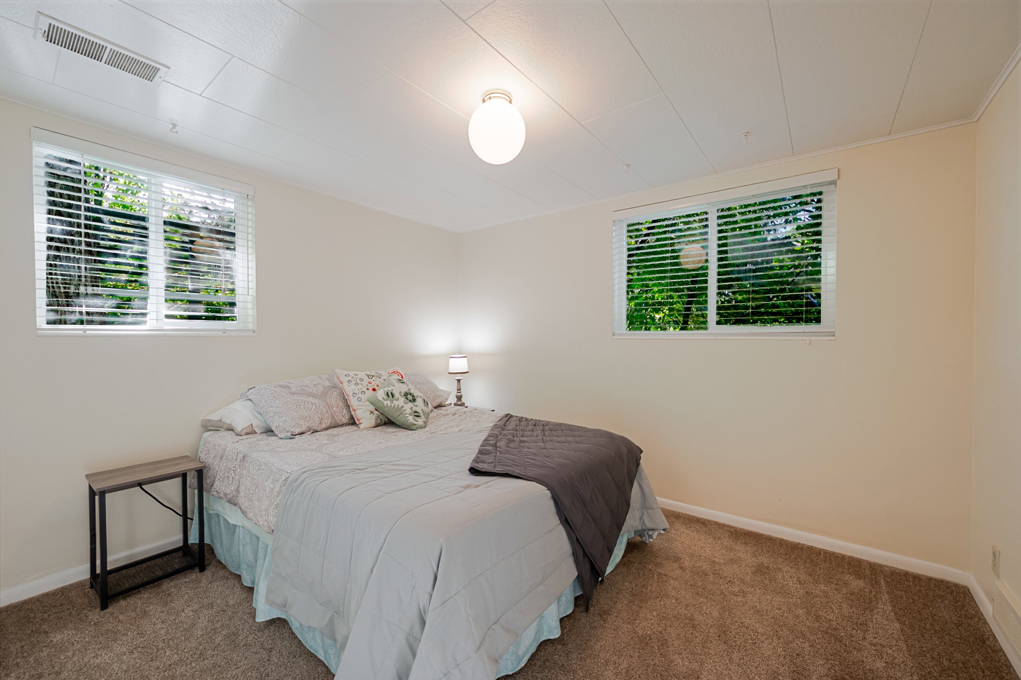 Large bright newly carpeted third bedroom with two windows