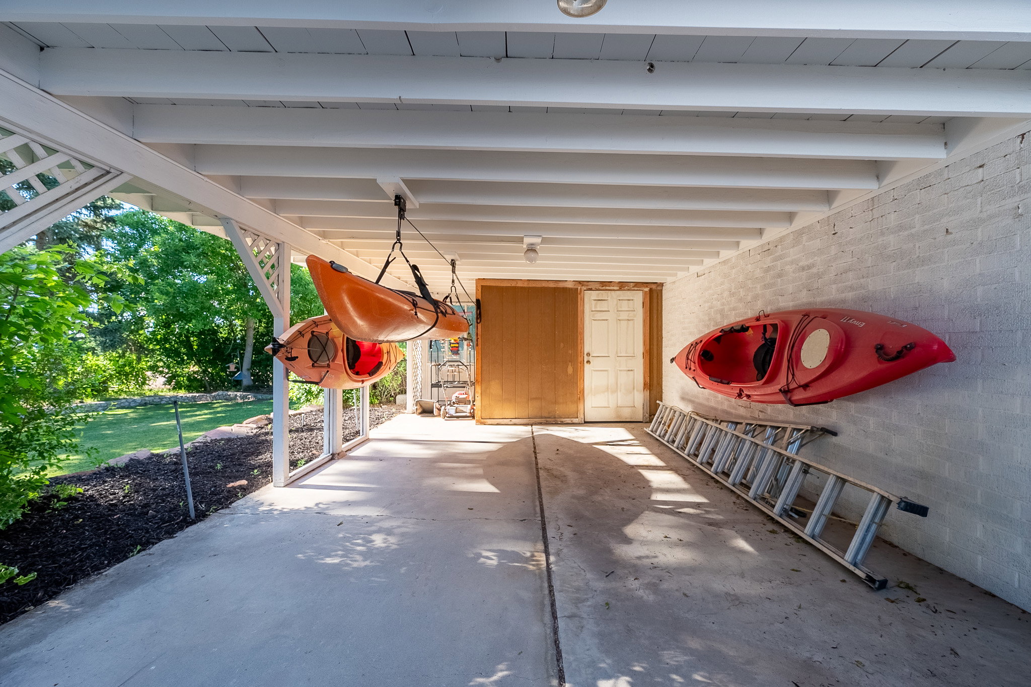 Covered carport with storage room at rear.
