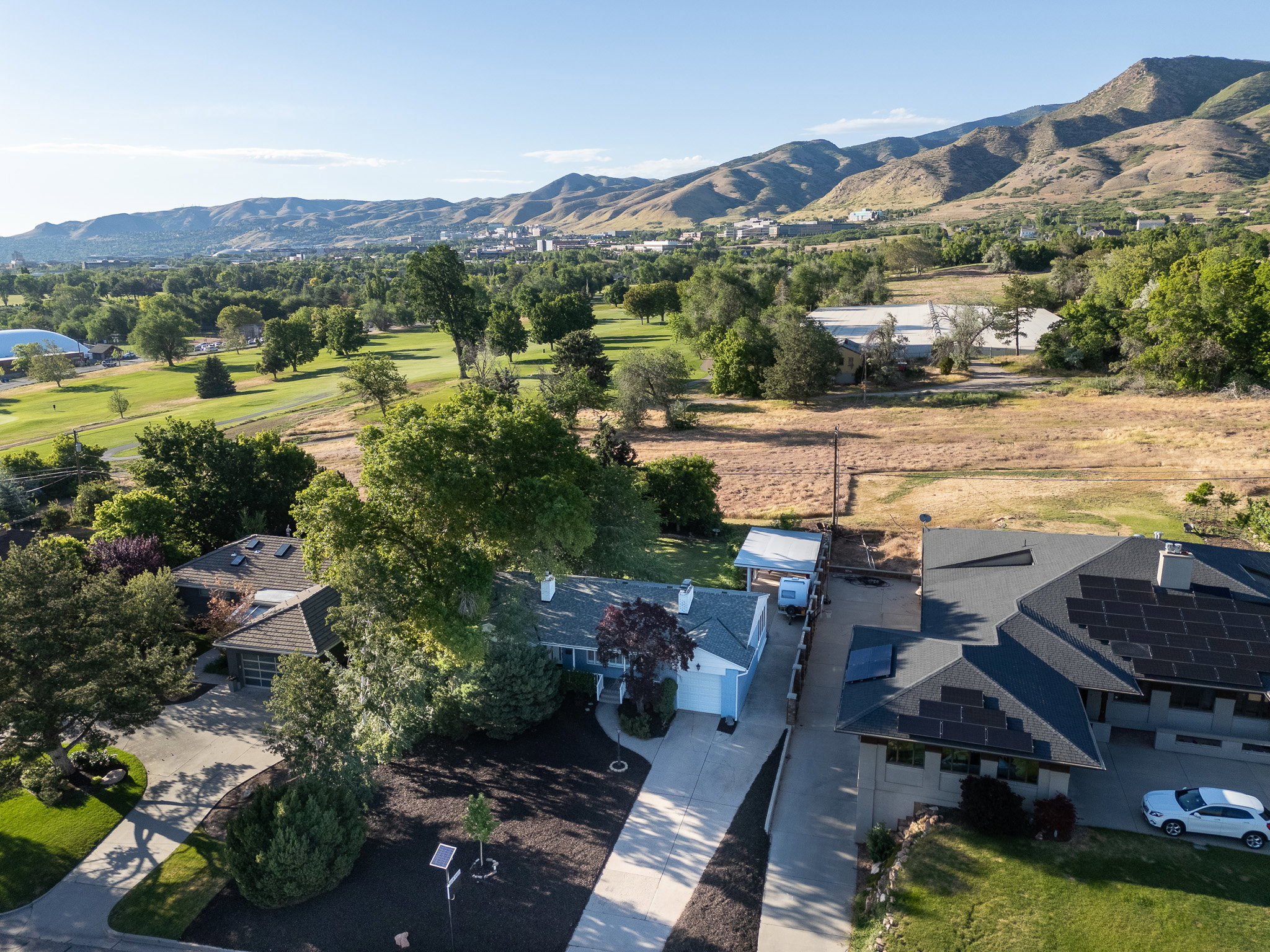 Rare opportunity  with this lot shown in Aerial perspective showcasing the property's back yard bordering Bonneville golf course with a stunnning city skyline and mountain backdrop