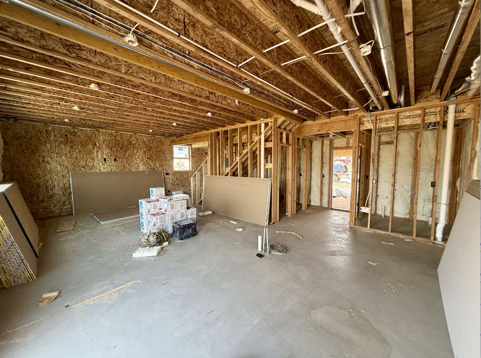 Unfinished interior space featuring exposed wood framing, ceiling joists, and a concrete floor