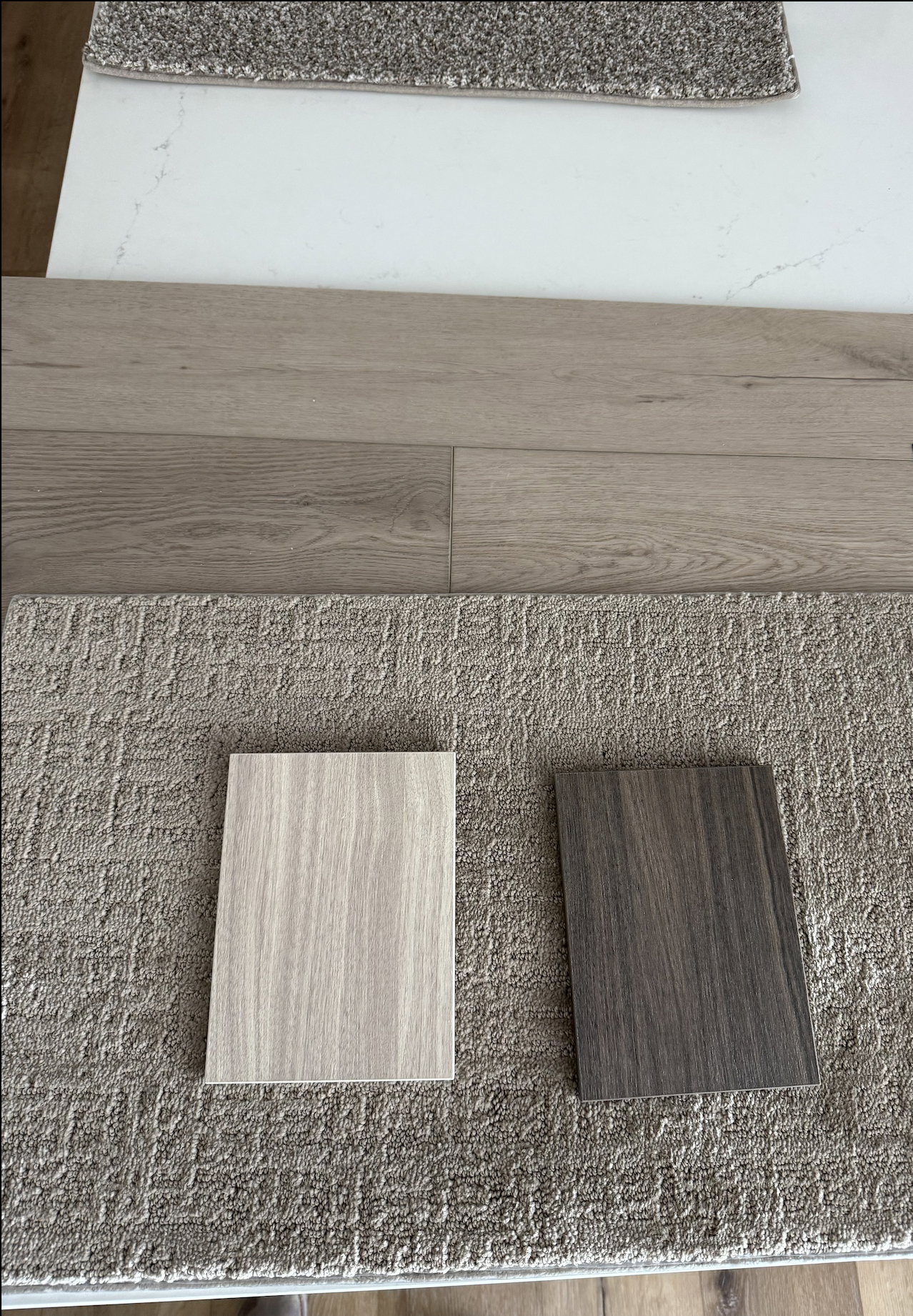 ILots 7, 9, and 11 will have two-toned kitchens. The lighter color will be used for everything except the island, which will be the darker color. The bathrooms in these will also have the darker cabinet color. The white countertop with light veining, LVP