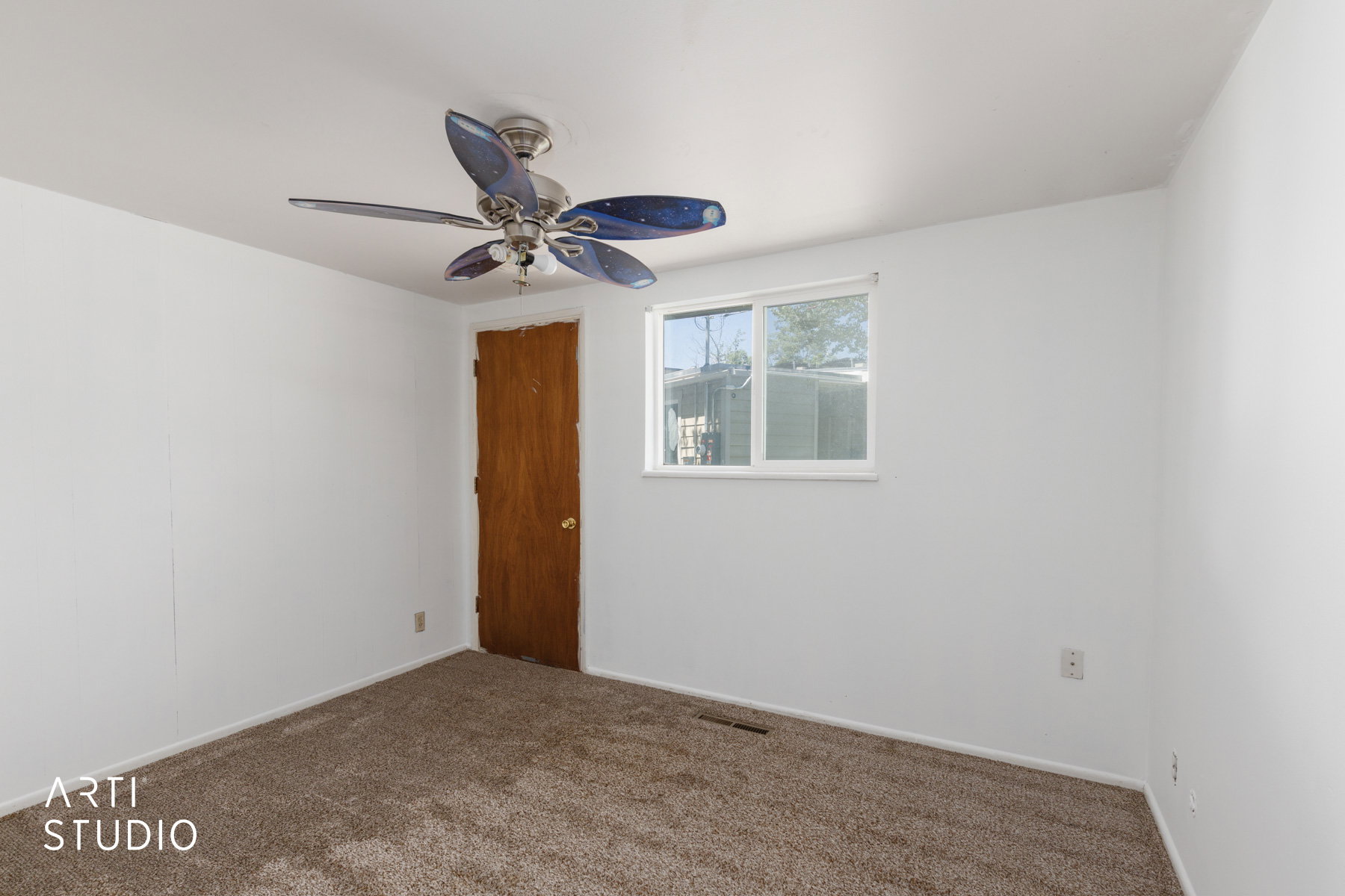 Carpeted room featuring a ceiling fan with integrated lighting, a single window, and a wood-finish door