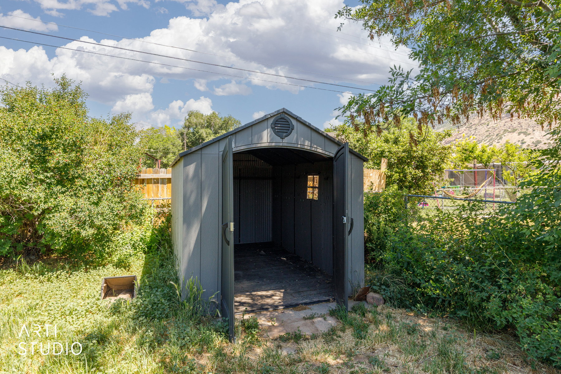 Outdoor storage shed with double doors, side window, and roof vent