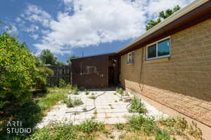 Exterior brick wall with two windows, featuring a brown trim and white gutters