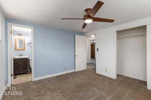Bedroom with blue accent wall, neutral carpet, and a ceiling fan with integrated lighting